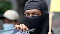 Seorang peserta aksi tampak memakai masker penutup wajah saat ikut serta dalam aksi unjuk rasa menuntut Kejaksaan Agung segera menuntaskan kasus sarang burung walet yang melibatkan Novel Baswedan.