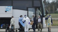 Para penumpang kapal pesiar Grand Princess turun dari bus untuk masuk ke dalam pesawat yang telah disewa untuk terbang menuju lokasi karantina. AP Photo/Jeff Chiu.