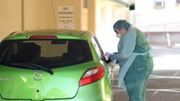 Seorang petugas medis di Rumah Sakit Repat yang berada di kawasan Adelaide, Australia, melakukan pemeriksaan terkait virus corona via drive-through.