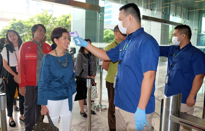 Petugas pengamanan melakukan pengecekan suhu tubuh karyawan dan pengunjung yang ada di lingkungan kerja kantor XL Axiata Tower dengan pengawasan ketat guna antisipasi penyebaran Corona.