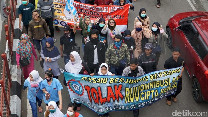 Blokade Jalan, Buruh dan Mahasiswa Tolak RUU Omnibus Law Massa buruh dan mahasiswa di Kota Cimahi berdemo menolak RUU Omnibus Law. Mereka sempat memblokade Jalan Amir Machmud.