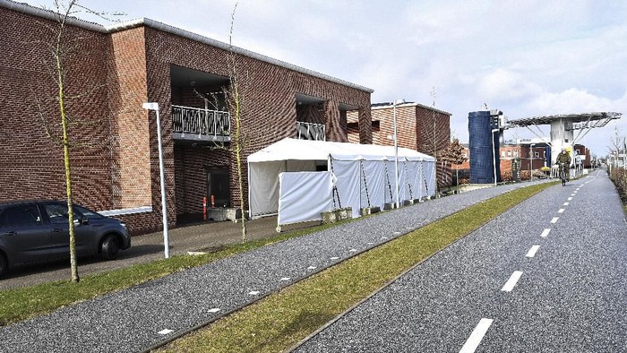 A tent serves as a drive-thru coronavirus testing facility at Aarhus University Hospital in Aarhus, Denmark, Monday March 9, 2020.  Locals are able to drive though the tented corridor, and met by a hospital worker who performs the COVID-19 test without the driver leaving their car. (Ernst van Norde/Ritzau via AP)