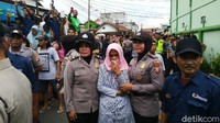 Terlihat juga ibu korban, Wati Candrawati, menyaksikan reka ulang itu didampingi anggota Polwan.