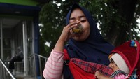 Warga tengah meminum jamu.
