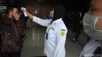 Satu per satu pengunjung diperiksa suhu tubuhnya oleh petugas.