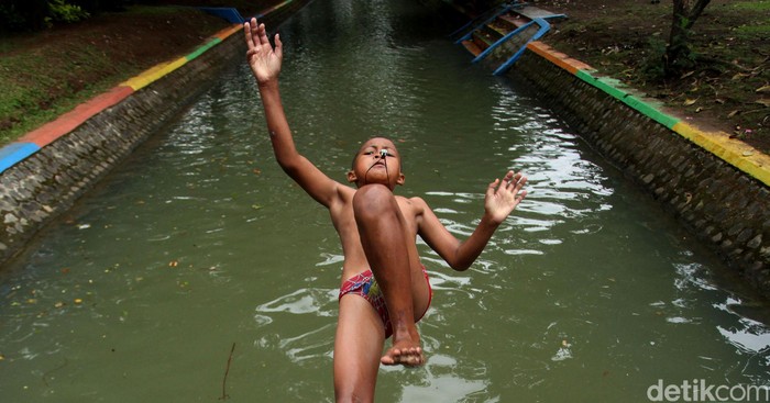 Aksi 'Loncat Indah' Anak-anak Tangerang di Kali Cisadane Sejumlah anak nampak asyik berenang di anak kali Cisadane, Tangerang, Kamis (12/3). Aliran Kali Cisadane dimanfaatkan anak-anak untuk bermain.