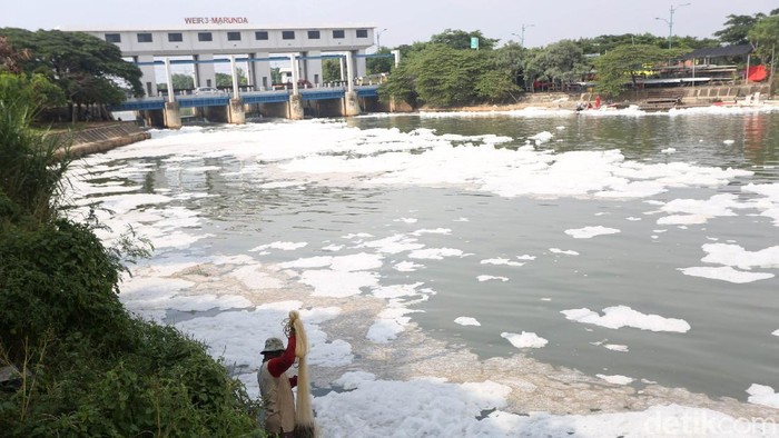 Warga beraktivitas di Pintu Air Kanal Banjir Timur Weir 3 Marunda, Jakarta Utara, Kamis (12/3/2020). Pintu air ini dipenuhi dengan busa berwarna putih. Hal ini terjadi diduga karena adanya pencemaran limbah domestik.