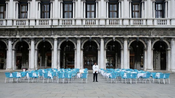 Namun sekarang, Italia dilockdown. Tampak seorang pelayan di Venesia sedang menanti tamu restoran, tapi tak ada seorang pun yang datang, padahal kursi-kursi sudah tertata rapi (Reuters) Namun sekarang, Italia dilockdown. Tampak seorang pelayan di Venesia sedang menanti tamu restoran, tapi tak ada seorang pun yang datang, padahal kursi-kursi sudah tertata rapi (Reuters)