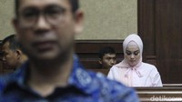 Dia duduk di bangku pengunjung sidang sebelum sidang dimulai.