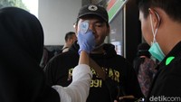 Petugas memeriksa suhu tubuh para pengunjung dengan menggunakan thermal gun.