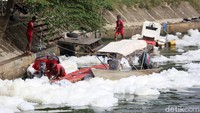 Sejumlah warga menyandarkan perahunya di pinggir sungai yang berbusa.