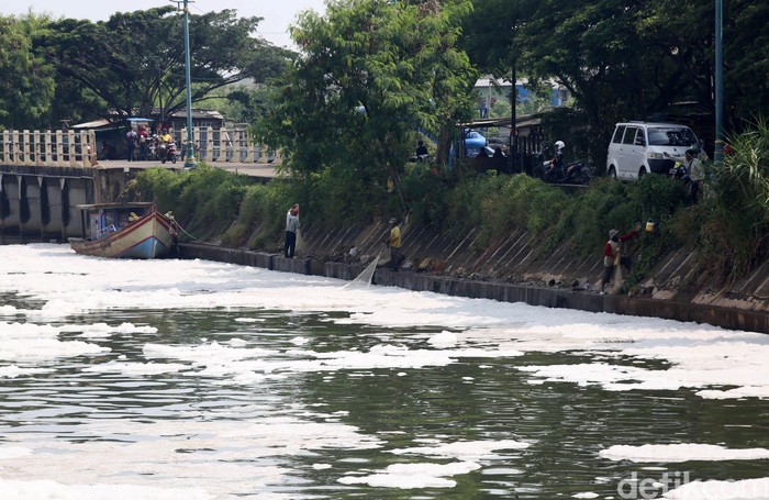Warga beraktivitas di Pintu Air Kanal Banjir Timur Weir 3 Marunda, Jakarta Utara, Kamis (12/3/2020). Pintu air ini dipenuhi dengan busa berwarna putih. Hal ini terjadi diduga karena adanya pencemaran limbah domestik.