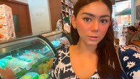 Berfoto di samping etalase, netizen banyak dibuat salah fokus dengan aneka kue-kue yang ada di etalase tersebut. Foto: Instagram @thalitalatief