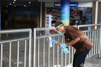Petugas Mengelap Bagian-bagian Mudah Disentuh di Bandara Ngurah Rai
