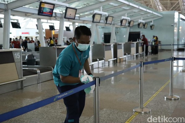 Ini merupakan bentuk komitmen pengelola Bandara Ngurah Rai untuk mengantisipasi adanya penularan virus Corona. Petugas mengelap tali pembatas di area check in (Foto: Angga Riza/detikcom) Ini merupakan bentuk komitmen pengelola Bandara Ngurah Rai untuk mengantisipasi adanya penularan virus Corona. Petugas mengelap tali pembatas di area check in (Foto: Angga Riza/detikcom)