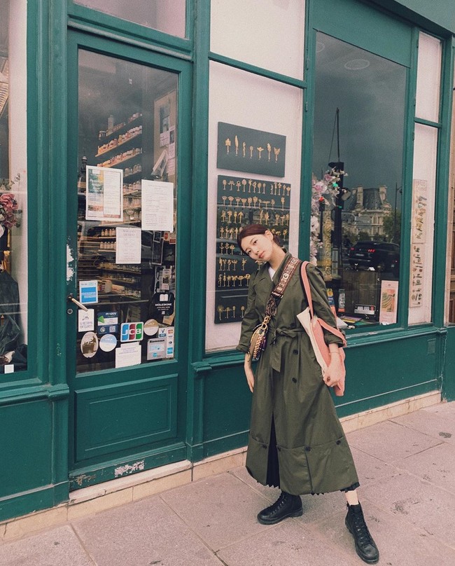 Outerwear panjang ternyata bisa terlihat lebih stylish ketika dipadukan rok lipit dan sepatu boots hitam. Gaya Suzy Bae ini bisa kamu tiru.  Foto: Instagram @skuukzky