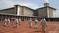 Usai melakukan sterilisasi, para petugas meninggalkan Masjid Istiqlal.