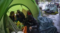 Sejumlah orang menghangatkan diri di dalam tenda yang kerap digunakan para tunawisma di kawasan Echo Park Lake di Los Angeles, Amerika Serikat, Kamis (12/3/2020) waktu setempat. AP Photo/Damian Dovarganes.