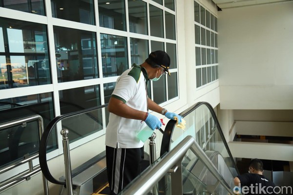 AP I Bandara I Gusti Ngurah Rai melakukan pembersihan dengan disinfektan di fasilitas terminal penumpang. Seorang petugas membersihkan pegangan eskalator (Foto: Angga Riza/detikcom) AP I Bandara I Gusti Ngurah Rai melakukan pembersihan dengan disinfektan di fasilitas terminal penumpang. Seorang petugas membersihkan pegangan eskalator (Foto: Angga Riza/detikcom)