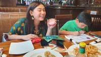 Sambil makan di restoran, Thalita Latief tetap mengajarkan anaknya untuk tetap belajar. Lihat meski makanan tampak menggoda, tetapi anaknya tetap fokus belajar. Foto: Instagram @thalitalatief