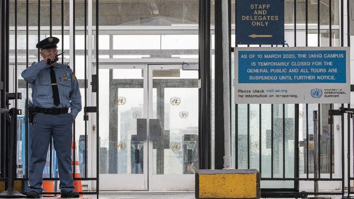 A United Nations security guard stands next to a sign at the entrance informing visitors that the U.N. is closed to the general public until further notice , Friday, March 13, 2020, in New York.  New York State has more than 400 confirmed cases of COVID-19, the disease caused by the virus. For most people, the new coronavirus causes only mild or moderate symptoms, such as fever and cough. For some, especially older adults and people with existing health problems, it can cause more severe illness, including pneumonia, and death. (AP Photo/Mary Altaffer)