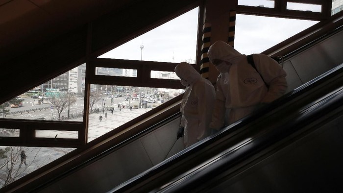 Workers wearing protective gears disinfect as a precaution against the new coronavirus at the subway station in Seoul, South Korea, Friday, March 13, 2020. For most people, the new coronavirus causes only mild or moderate symptoms, such as fever and cough. For some, especially older adults and people with existing health problems, it can cause more severe illness, including pneumonia. (AP Photo/Lee Jin-man)