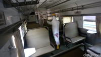 Satu per satu area di dalam gerbong kereta disemprotkan disinfektan oleh petugas.