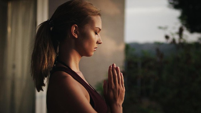 yoga namaste Namaste gesture close up photo, young attractive woman practicing yoga, working out, wearing wrist bracelets and rings, indoor, yoga studio, behind the shoulder view. Contemplation concept