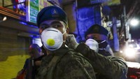 Para petugas kepolisian dan tentara yang bersiaga di kawasan Manila, Filipina, tampak mengenakan masker pelindung pernapasan saat bertugas.