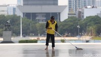 Seorang petugas tampak sedang membersihkan area depan Monas yang ditutup sementara guna mencegah penyebaran virus corona.