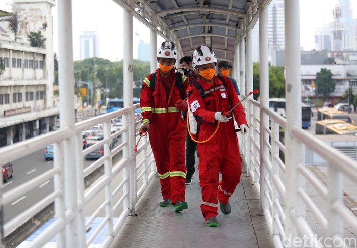 Penyemprotan disinfektan dilakukan sebagai upaya cegah penyebaran corona. Area ruang publik seperti halte bus TransJakarta jadi sasaran penyemprotan disinfektan