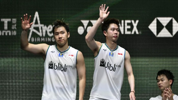 Marcus Fernaldi Gideon, left, and Kevin Sanjaya Sukamuljo of Indonesiaand wave from the podium after loosing to Yuta Watanabe and Hiroyuki Endo of Japan in the Mens Doubles final match at the All England Open Badminton tournament in Birmingham, England, Sunday, March 15, 2020. The Japanese team won 2-1. (AP Photo/Rui Vieira)