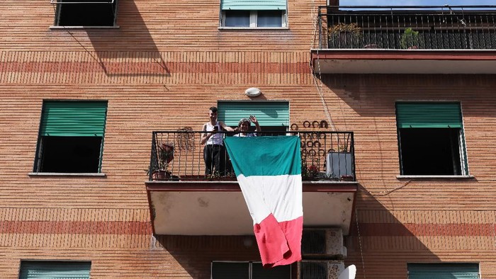 ROME, ITALY - MARCH 15: Ostia residents look out the windows during a musical flash mob to shown their gratitude to health personnel on the coronavirus frontline by applauding from their windows on March 15, 2020 in Rome, Italy. Ostias streets, one of Rome neighborhood were eerily quiet on the forth day of a nationwide quarantine. The Italian Government has taken the unprecedented measure of a nationwide lockdown by closing all businesses except essential services such as, pharmacies, grocery stores, hardware stores, tobacconists and banks, in an effort to fight the worlds second-most deadly Coronavirus (COVID-19) outbreak outside of China.The movements in the streets are allowed only for work reasons and health reasons proven by a medical certificate. Citizens are encourage to stay home and have an obligation to respect the safety distance of one meter from each other in a row at supermarkets or in public spaces. According to the Ministry of the Interior, of the over half a million people controlled by the police in the past four days, over 20 thousand people have been reported for violating the quarantine. (Photo by Marco Di Lauro/Getty Images)