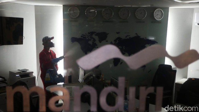 Petugas melalukan penyemprotan disinfektan di Kantor Bank Mandiri Cabang Thamrin, Jakarta, Senin (16/3/2020). Penyemprotan ini dilakulan guna mencegah penyebaran virus corona.
