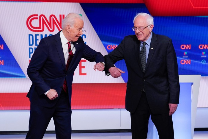 Election 2020 Debate Coronavirus Former Vice President Joe Biden, left, and Sen. Bernie Sanders, I-Vt., right, greet one another before they participate in a Democratic presidential primary debate at CNN Studios in Washington, Sunday, March 15, 2020. (AP Photo/Evan Vucci)