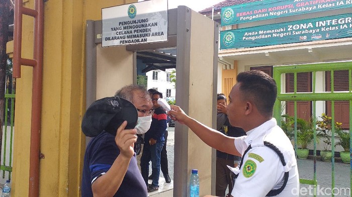 Mencegah penyebaran virus corona, Pengadilan Negeri (PN) Surabaya melakukan pengecekan suhu badan. Selain itu, tak ada adegan salaman usai sidang antara terdakwa dan hakim.