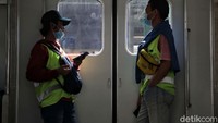 Dua orang penumpang mengenakan masker saat menaiki KRL di Jakarta.