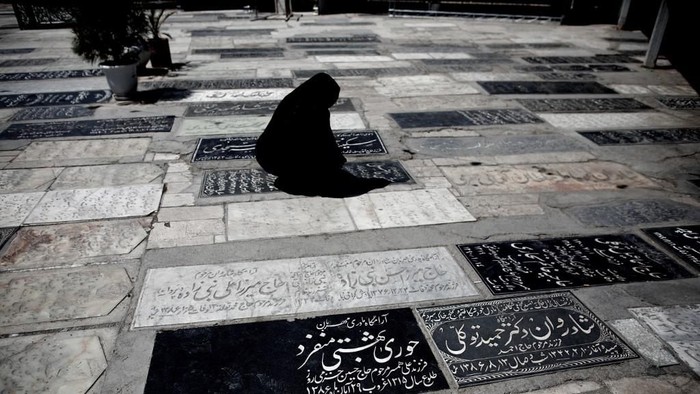 An Iranian woman visits a relatives grave at a cemetery in the religious Shiite city of Qom, some 130 kilometres south of the capital, on June 9, 2013. AFP PHOTO/BEHROUZ MEHRI (Photo by BEHROUZ MEHRI / AFP)