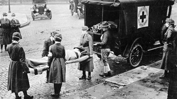 Pekerja Palang Merah mengangkut korban ke mobil ambulans. Pada saat itu terjadi Perang Dunia I sehingga banyak tentara bepergian dan virus pun makin menyebar. Foto: National Archives