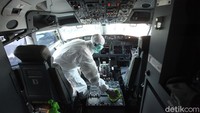 Usai menyisir setiap bangku pesawat, petugas membersihkan ruang pilot dan kopilot.