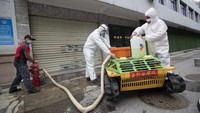 Petugas mengisi cairan disinfektan ke mobil robot. Dengan cara ini risiko tertular virus corona bisa diminimalkan (AP/Aaron Favila)