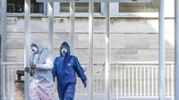 Dua orang petugas medis bersiap untuk mengevakuasi pasien virus corona yang diangkut oleh mobil ambulans untuk menjalani perawatan secara intensif di rumah sakit. AP Photo/Luca Bruno.