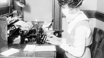 Seorang pengetik di Washington memakai masker. Wabah Flu Spanyol diestimasi membunuh sedikitnya 17 juta sampai 50 juta orang. Foto: National Archives