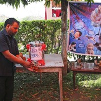 Karikatur virus corona terpampang di acara tersebut. Apakah air kencing seni benar-benar ampuh menangkal virus corona? Menurut Reuters, belum ada bukti medis yang mendukung klaim mereka. (Foto: AP/Altaf Qadri)