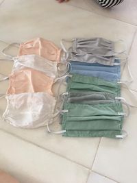 Seorang ibu di usianya yang tua menjahit masker untuk anak-anaknya