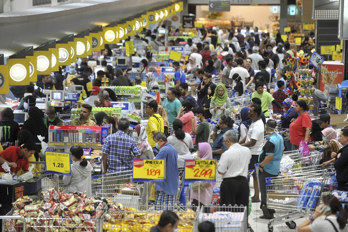Shoppers looking at empty shelves at a supermarket in Kuala Lumpur, Malaysia, Tuesday, March 17, 2020. Malaysia has the highest number of cases in Southeast Asia and the fourth highest in Asia following a spike in recorded coronavirus cases after China, South Korea and Japan. For most people, the new coronavirus causes only mild or moderate symptoms. For some it can cause more severe illness. (AP Photo)