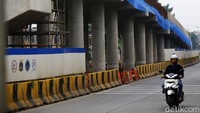 Kendaraan melintas di samping proyek pembangunan flyover Lenteng Agung, Rabu (18/3).