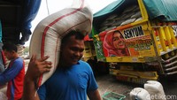 Pekerja melakulan aktivitas bongkar muat beras di Pasar Induk Beras Cipinang, Jakarta Timur, Rabu (18/3/2020).