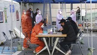 Korea Selatan pun membuka posko tes Corona bagi masyarakat di sejumlah wilayah, salah satunya di Seoul, ibu kota Korea Selatan. Korsel diketahui menggunakan alat tes Corona dari SD Biosensor, sebuah perusahaan farmasi asal Negeri Ginseng. Foto: AP/Ahn Young-joon