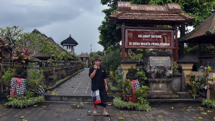 Pecalang atau petugas keamanan adat berjaga di kawasan pintu masuk Desa Wisata Penglipuran, Bangli, Bali, Rabu (18/3/2020). Desa Adat Penglipuran memutuskan tidak menerima kunjungan wisatawan sementara waktu dari 18 hingga 30 Maret 2020 untuk pencegahan penyebaran COVID-19 atau Virus Corona. ANTARA FOTO/Nyoman Hendra Wibowo/nym/foc.